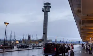 Wieża kontrolna na oslo lotnisko. Ludzie z bagażami wsiadają do vana.