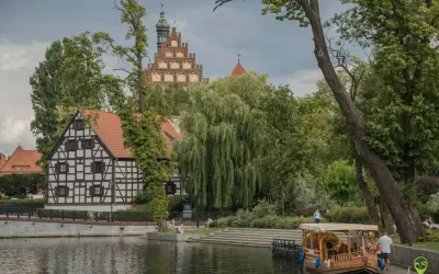 Nad wodą, wśród zieleni, widać zabytkowe kamieniczki i wieżę kościelną. To jedno z magicznych miejsc Kujawsko-Pomorskiego.