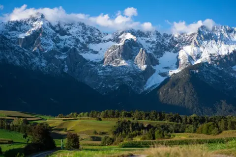 Gdzie jest Tyrol? Widać tu ośnieżone szczyty górskie, zielone pola i lasy.