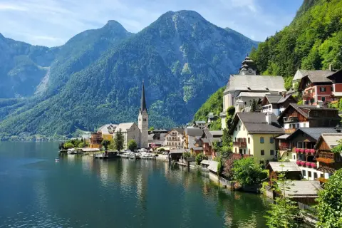 Malownicze domy nad jeziorem, w tle góry i kościół. To Hallstatt, gdzie znajduje się słynna kopalnia soli.