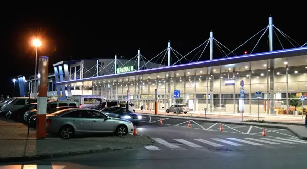 Nocne zdjęcie Terminala A lotniska, z którego można wyruszyć do Rzeszowa lub Katowic.