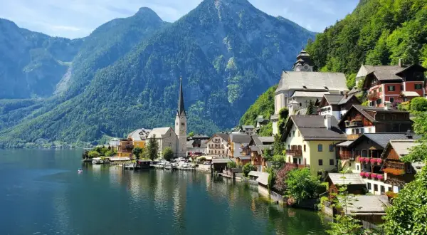 Malownicze domy nad jeziorem, w tle góry i kościół. To Hallstatt, gdzie znajduje się słynna kopalnia soli.