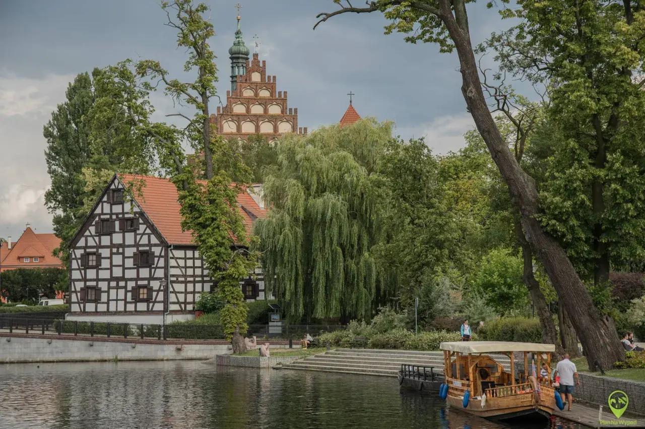 Nad wodą, wśród zieleni, widać zabytkowe kamieniczki i wieżę kościelną. To jedno z magicznych miejsc Kujawsko-Pomorskiego.