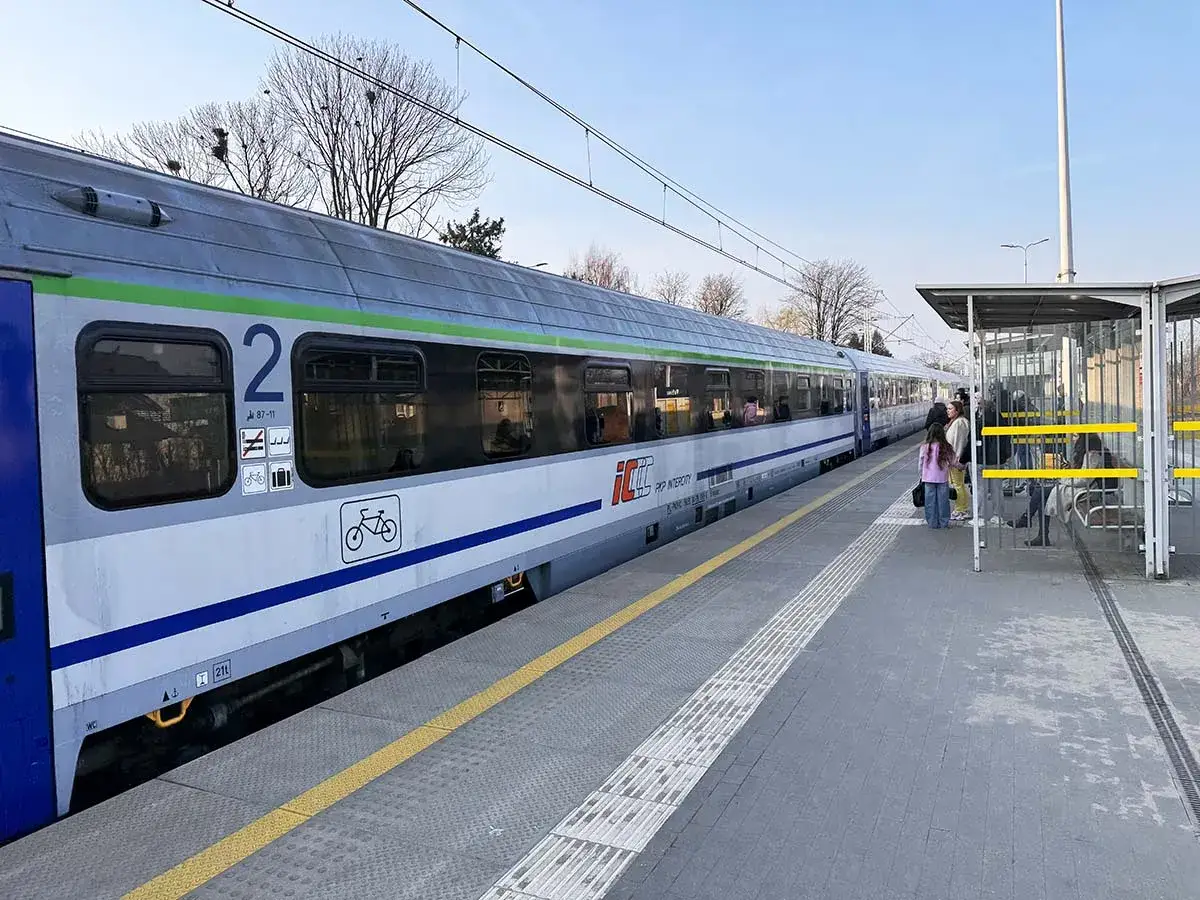 Pociąg Intercity na stacji w Pabianicach, niedaleko Łodzi. Ludzie czekają na peronie.