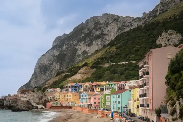 Kolorowe domy nad zatoką u stóp skały Gibraltar, przypominające widok z Sewilli.